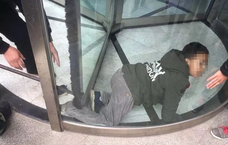 男孩脚卡旋转门 消防员及时解救